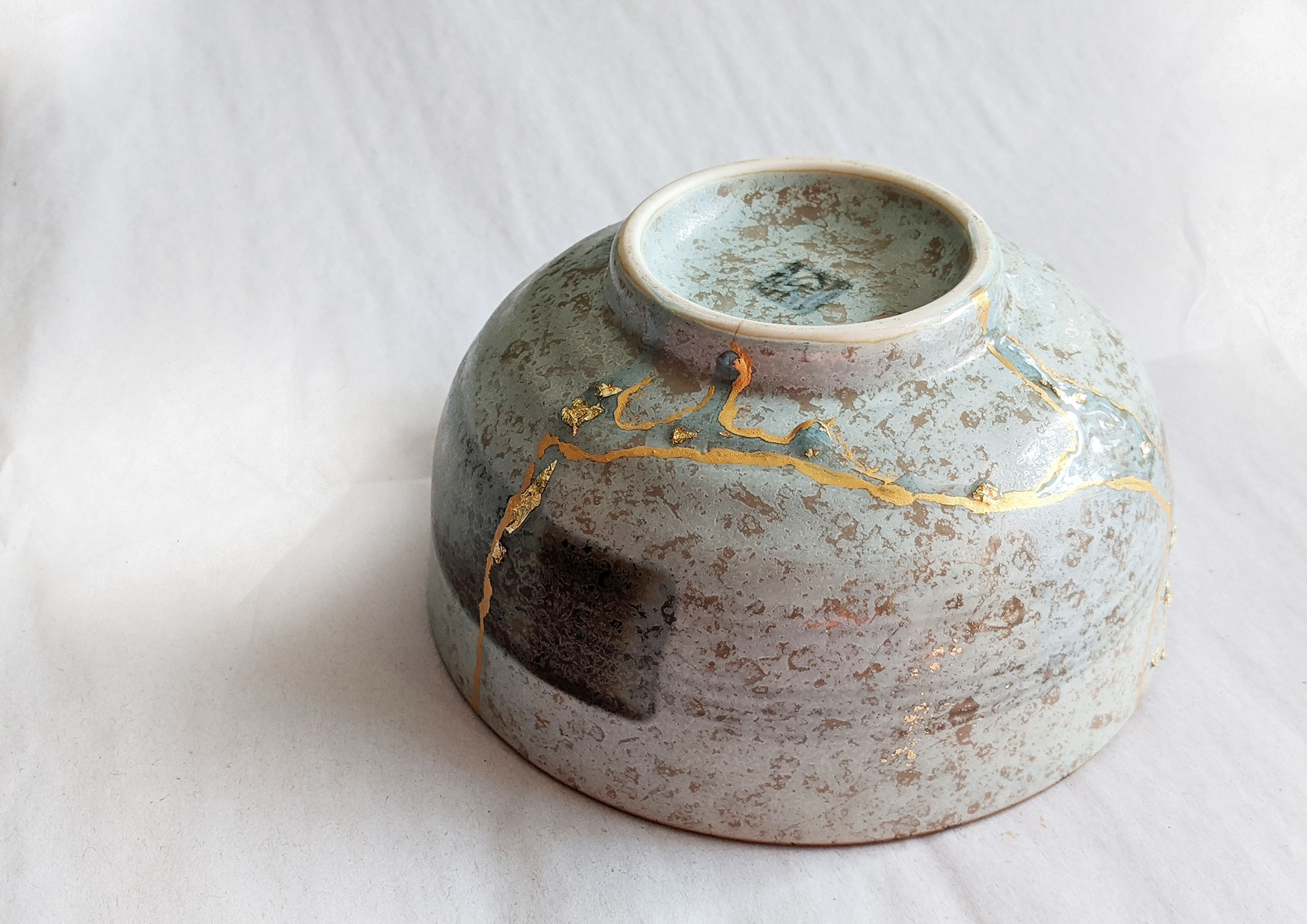 Kintsugi Repair: Gold color plus resin embedded with gold flakes by Fan Stanbrough