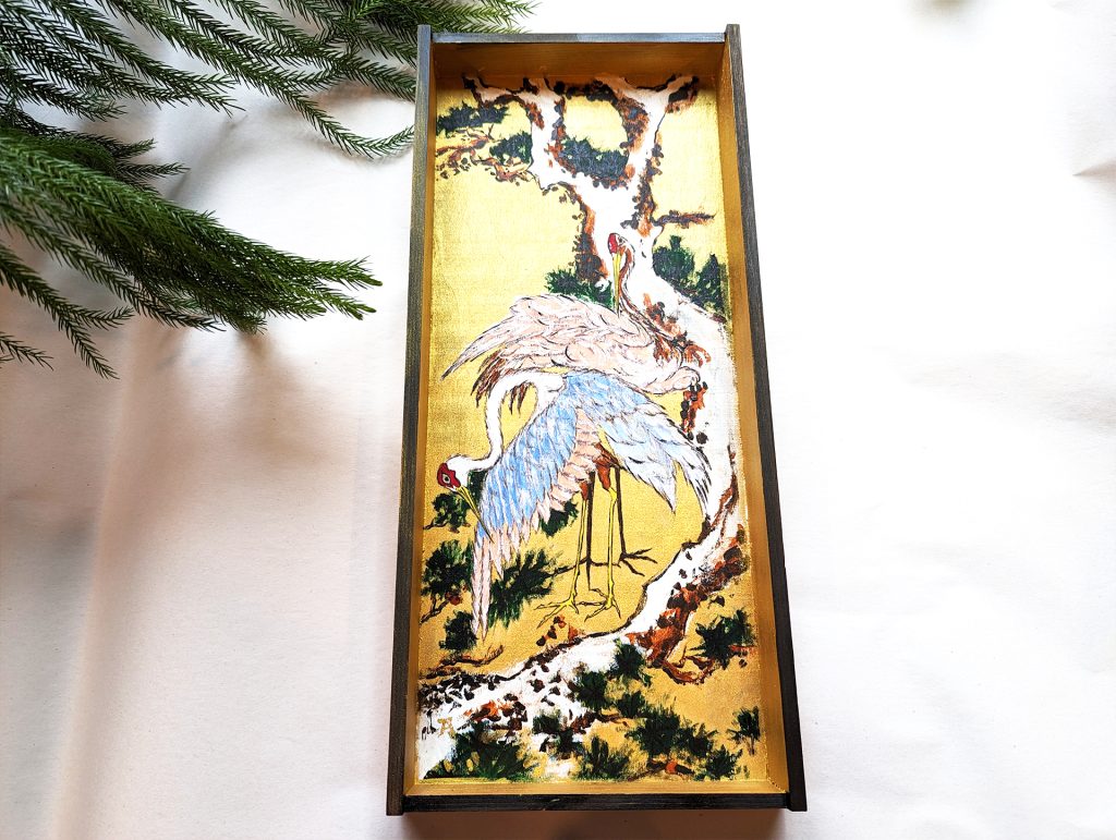 Cranes on Branch of Snow-covered Pine on a Wooden Box